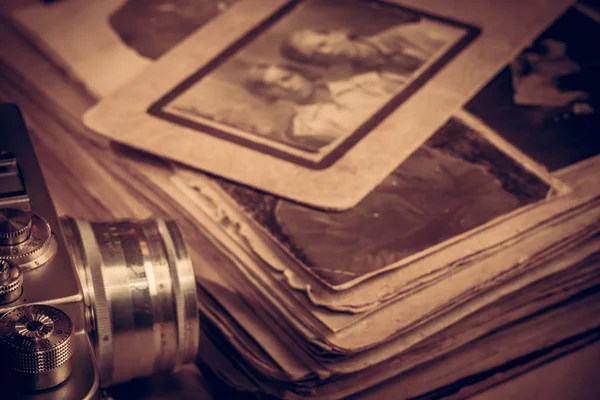 Молода людина розглядає старий сімейний фотоальбом та цифрове родове дерево на планшеті